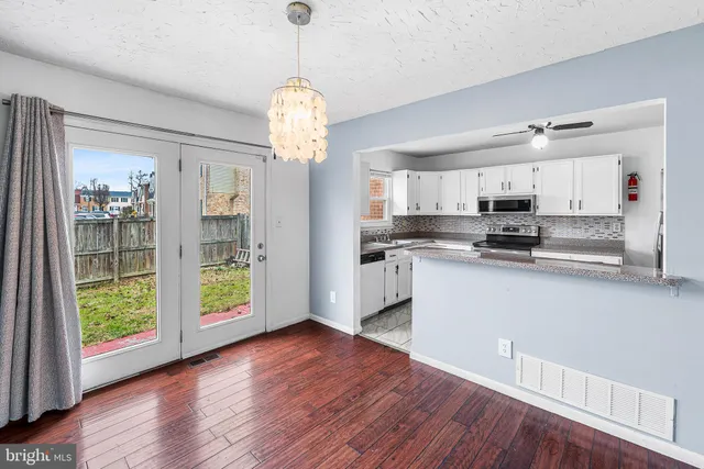a view of a kitchen with stainless steel appliances granite countertop a stove top oven
