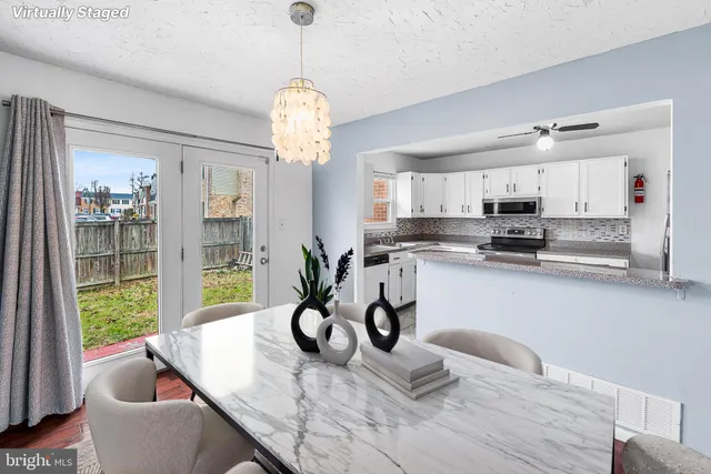 a kitchen with stainless steel appliances granite countertop a sink dishwasher a dining table and chairs with wooden floor