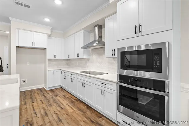 a kitchen with stainless steel appliances white cabinets and stove