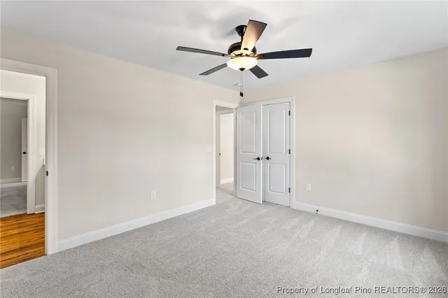 an empty room with a ceiling fan and a window
