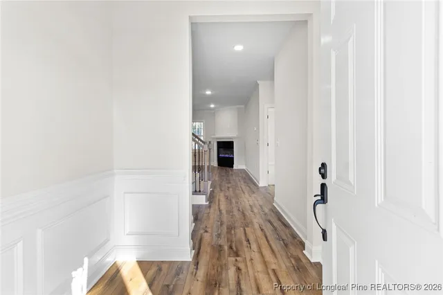 a view of a hallway with wooden floor and staircase