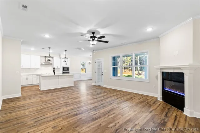 a view of an empty room with a kitchen and a window