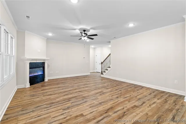 a view of an empty room with a ceiling fan and window
