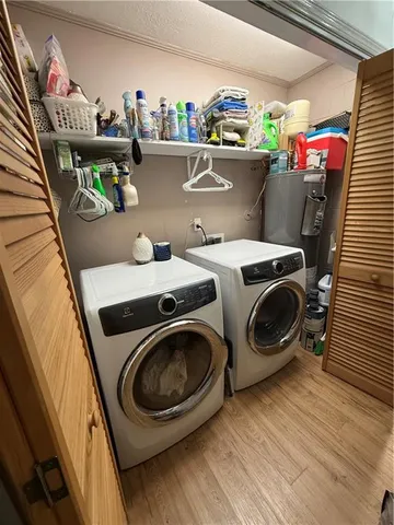 a utility room with dryer washer and a view of living room