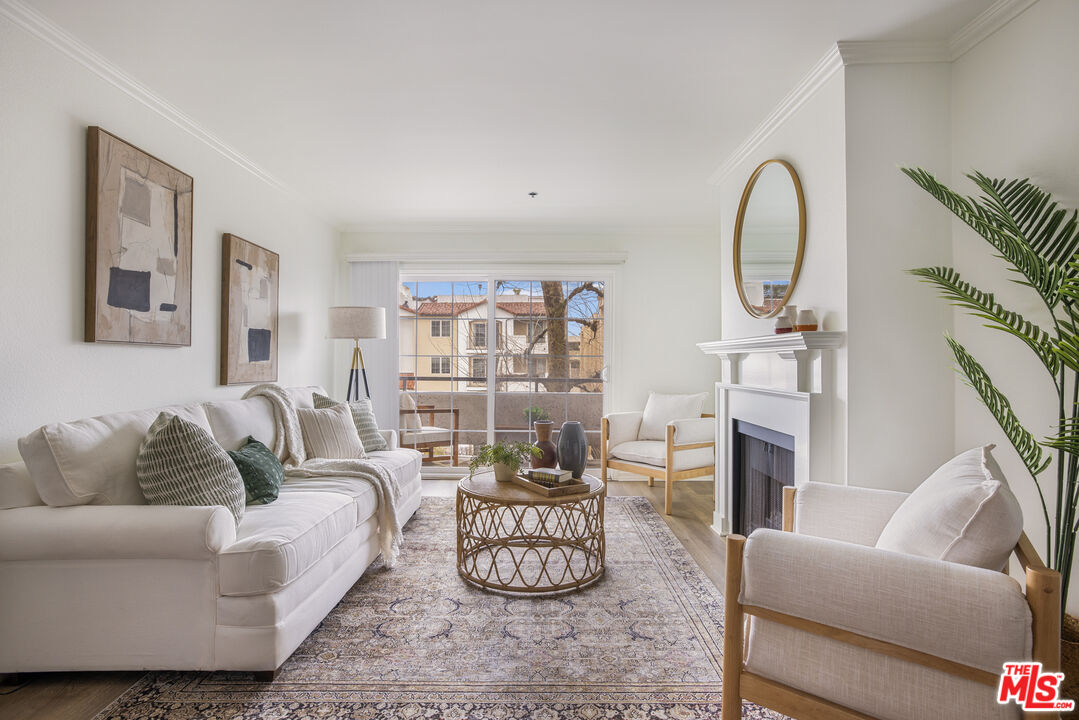 a living room with furniture potted plant and a large window