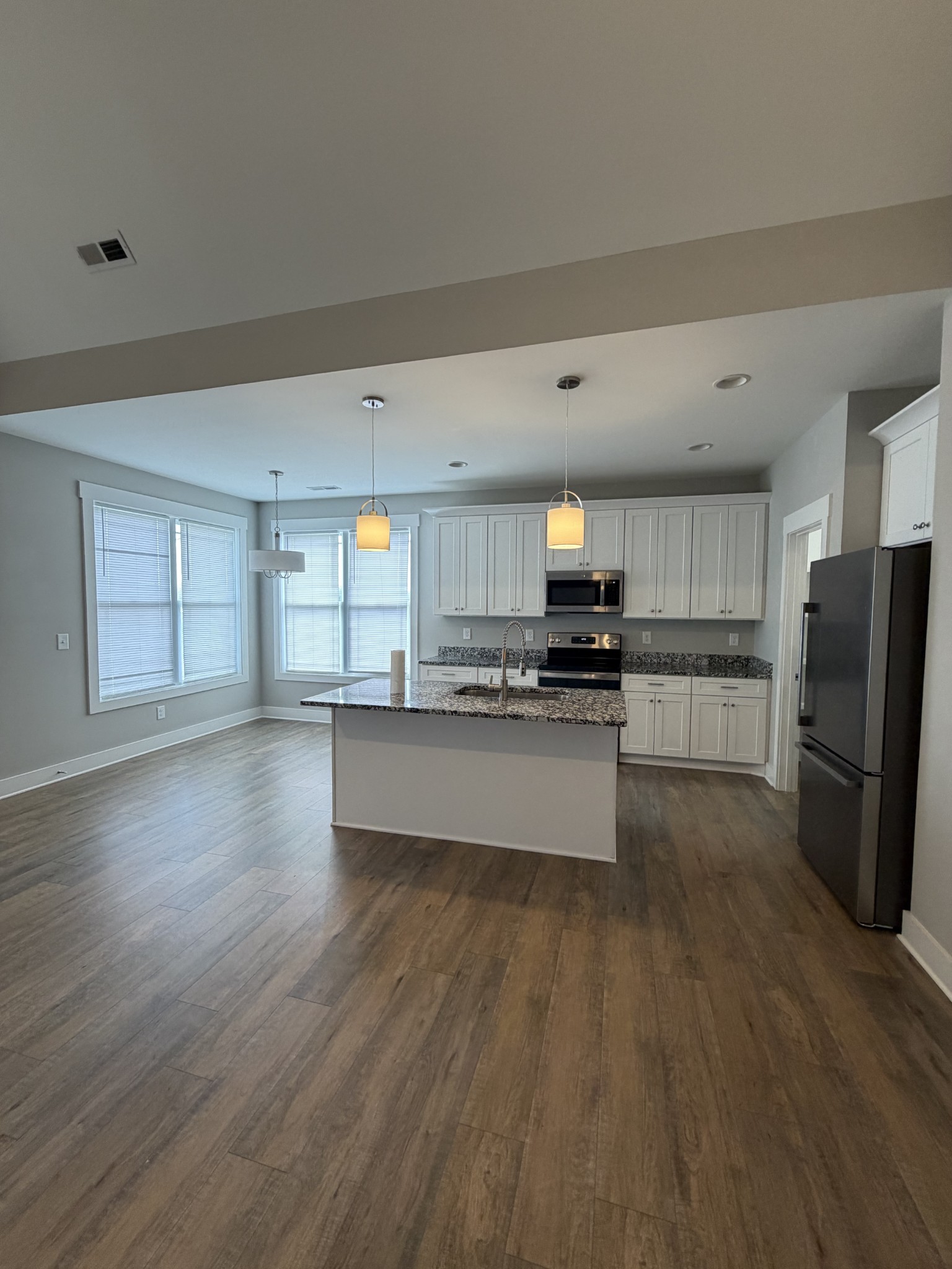 442 Bill Fuson Road McMinnville, TN 37110 - Photo 4 of 29 a large kitchen with stainless steel appliances wooden floors and wooden cabinets