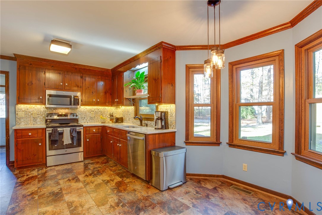 12930 Donegal Drive Chesterfield, VA 23832 - Photo 9 of 43 a kitchen with stainless steel appliances granite countertop a stove top oven a sink dishwasher a dining table and chairs with wooden floor