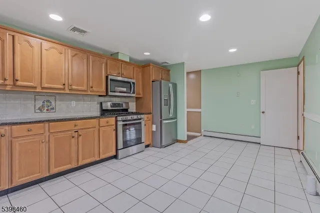 a kitchen with granite countertop a refrigerator and cabinets