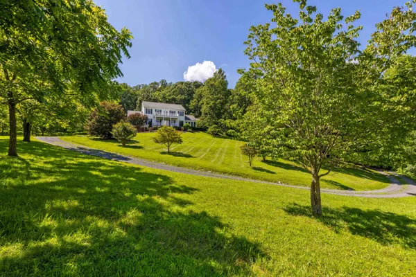 a view of a hallway with wooden floor and a chandelier