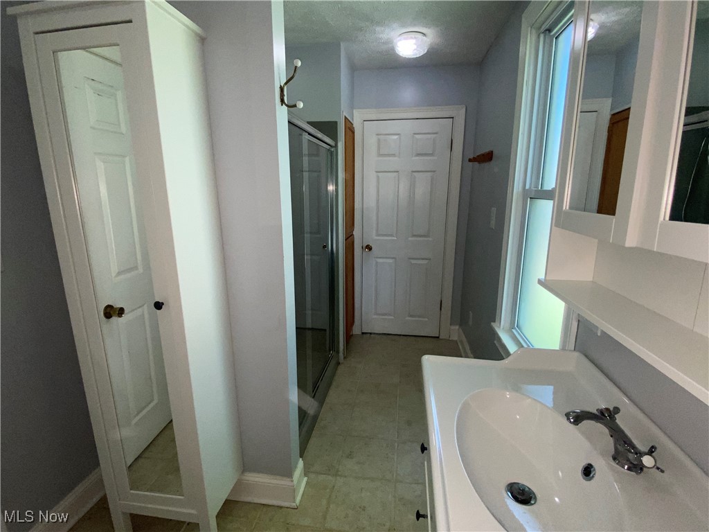 3016 Wadsworth Road Norton, OH 44203 - Photo 25 of 50 Bathroom featuring vanity, tile patterned floors, and walk in shower