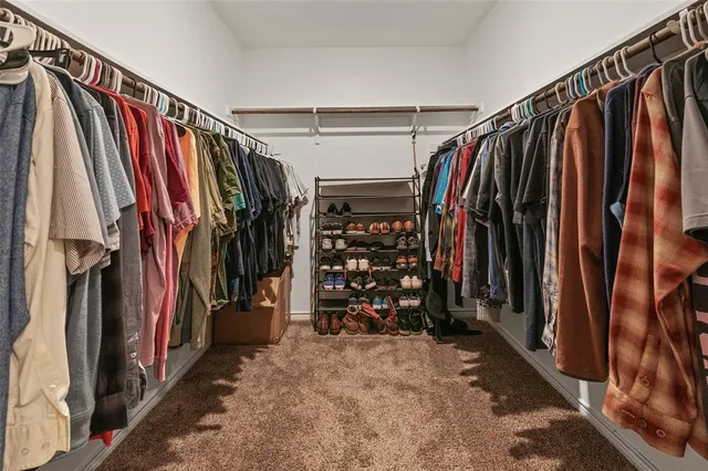 a view of walk in closet with clothes