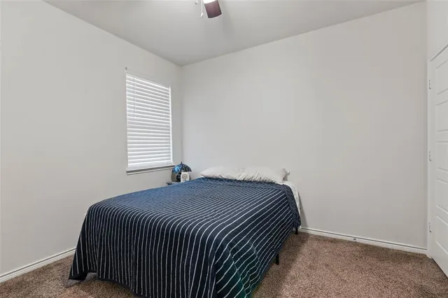 a bed sitting in a bedroom next to a window