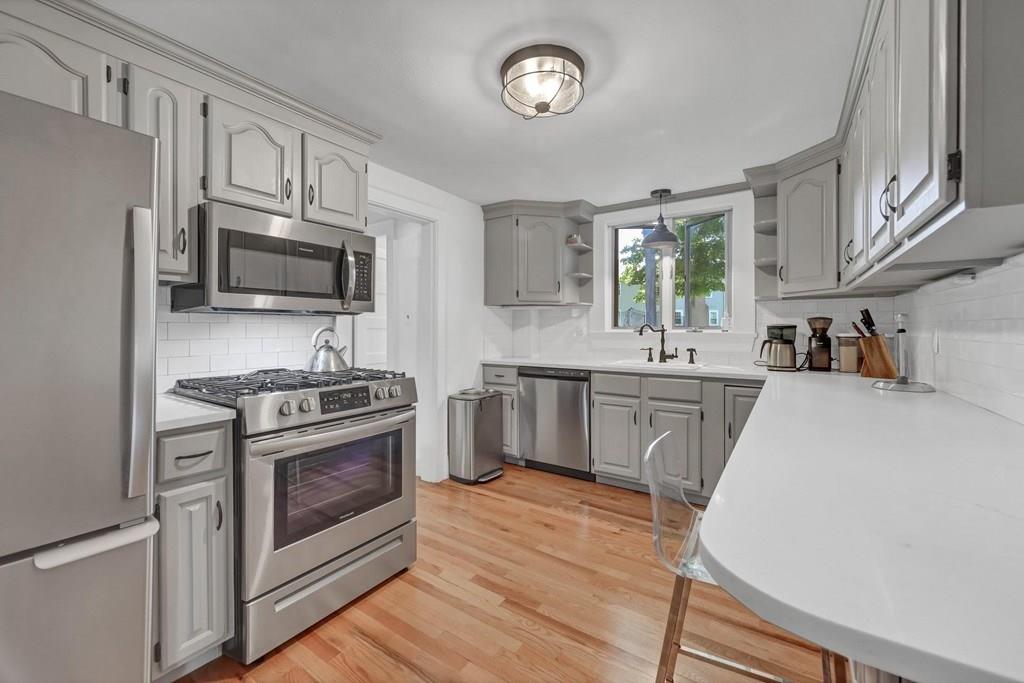29 Waldeck Road Milton, MA 02186 - Photo 4 of 13 a kitchen with stainless steel appliances a stove microwave and a refrigerator