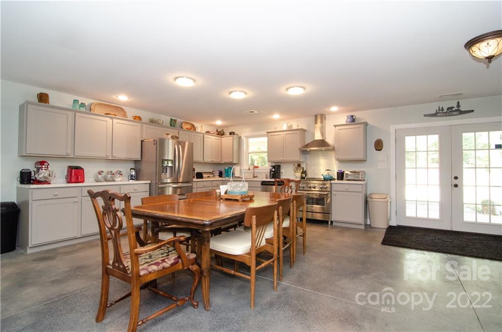 3267 Park Road Ridgeway, SC 29130 - Photo 7 of 40 a kitchen with a dining table chairs and white cabinets