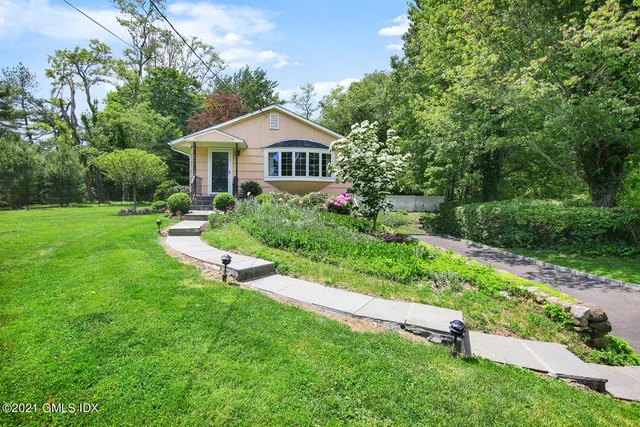 a front view of a house with yard and green space