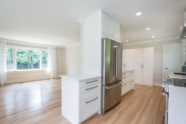 a kitchen with granite countertop a refrigerator and a stove top oven