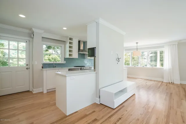 a kitchen with a refrigerator and wooden floor