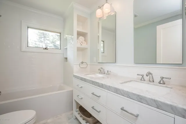 a bathroom with a granite countertop toilet sink and mirror