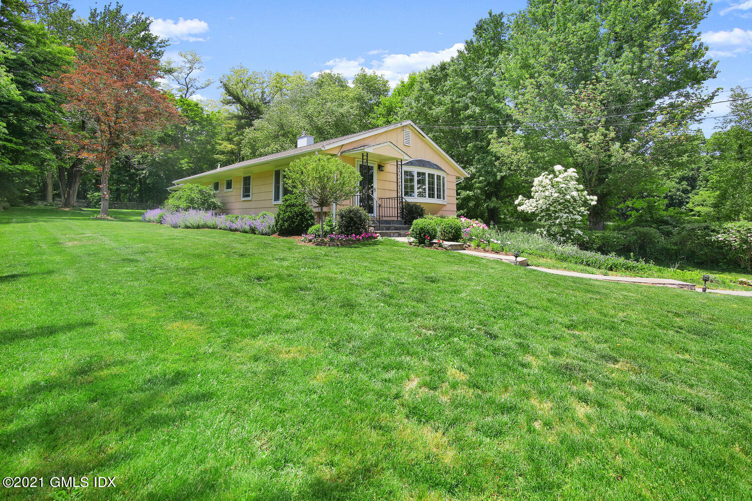 395 Taconic Road Greenwich, CT 06831 - Photo 2 of 36 a aerial view of a house next to a yard with potted plants and large trees