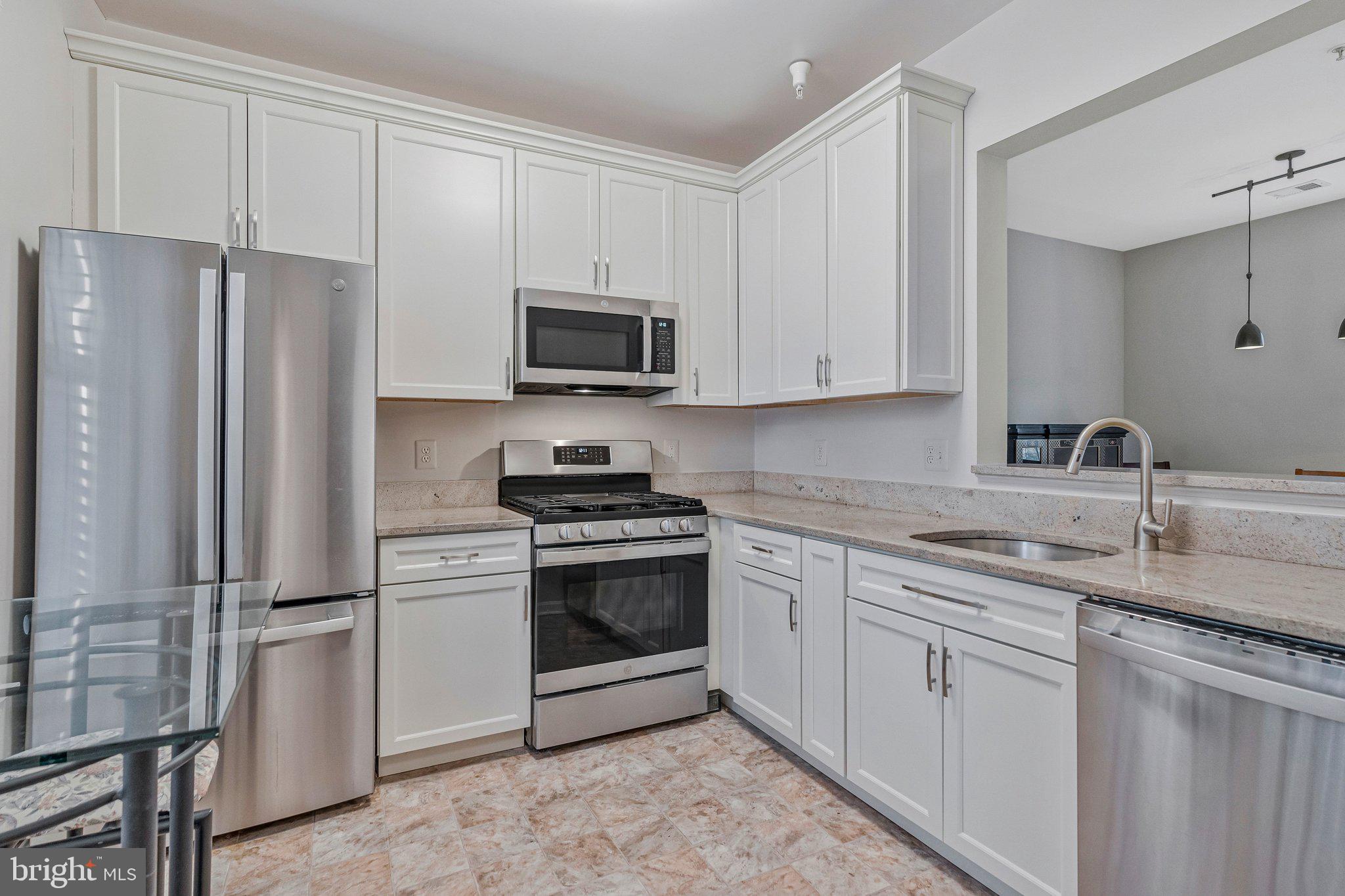 11405 Windleaf Court, Unit 23 Reston, VA 20194 - Photo 5 of 24 a kitchen with stainless steel appliances granite countertop a refrigerator stove microwave and sink