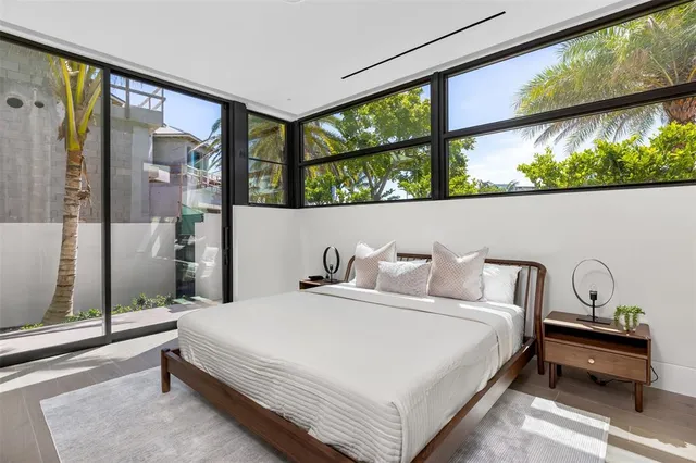 a bedroom with a bed and large window