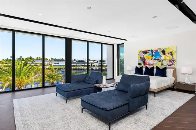 a view of a swimming pool with a lawn chairs and palm trees