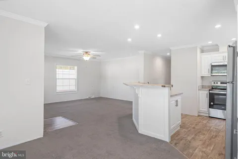 a view of a kitchen with a sink and dishwasher a refrigerator with white cabinets