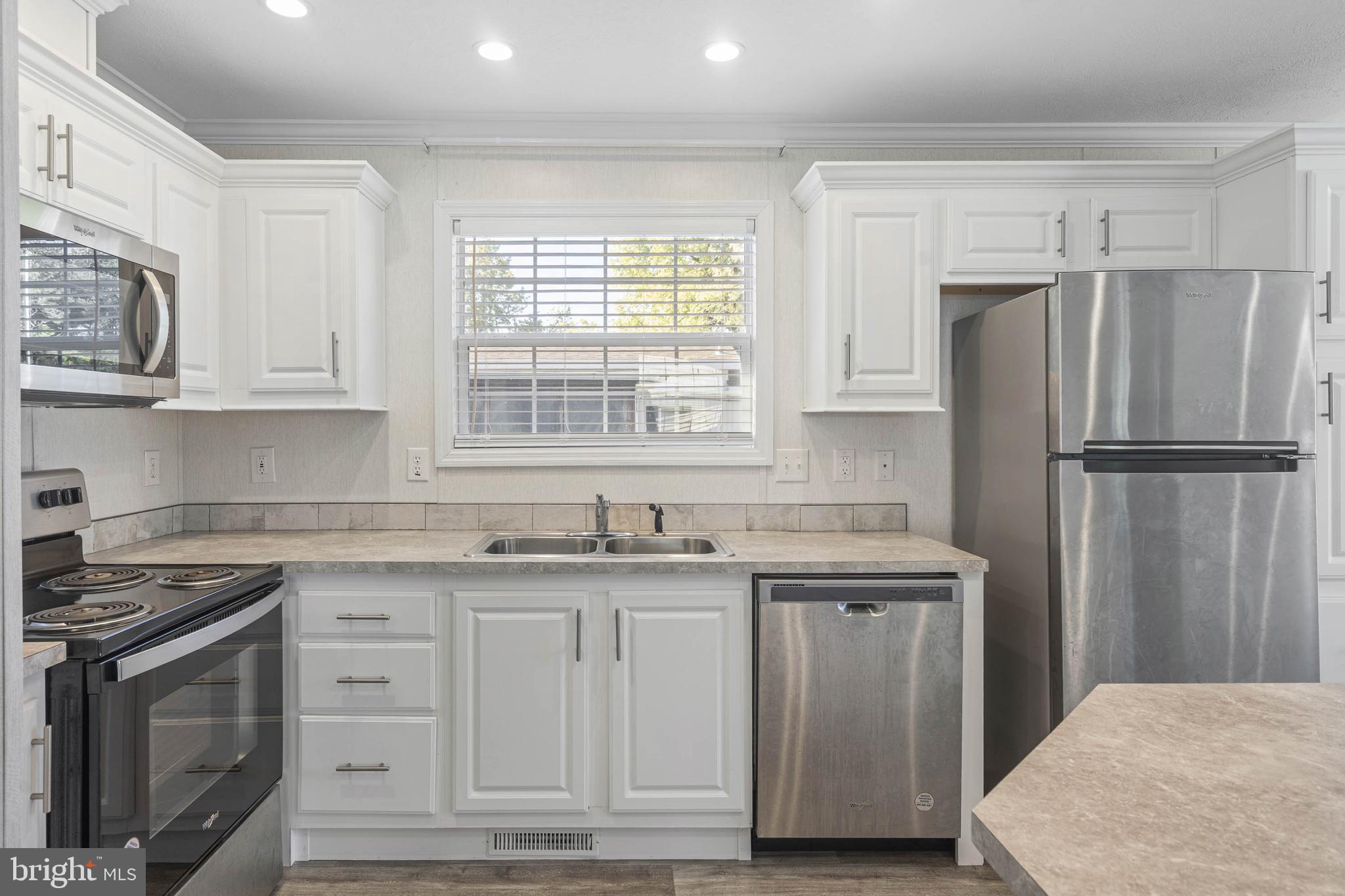 17247 Pine Water Drive Lewes, DE 19958 - Photo 2 of 32 a kitchen with granite countertop a sink stove and refrigerator