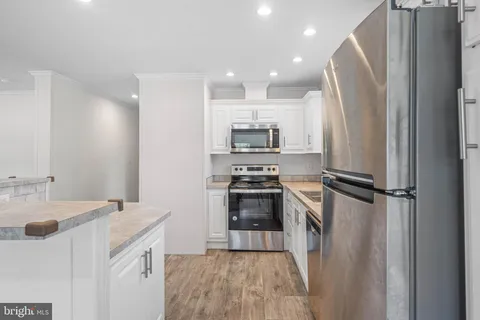 a kitchen with a sink stainless steel appliances and cabinets