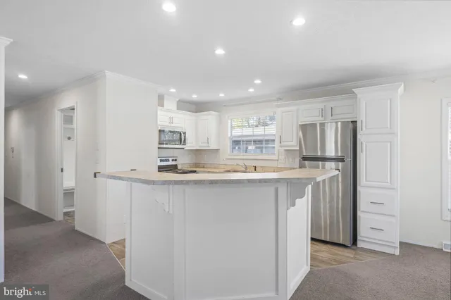 a kitchen with stainless steel appliances a refrigerator sink and cabinets