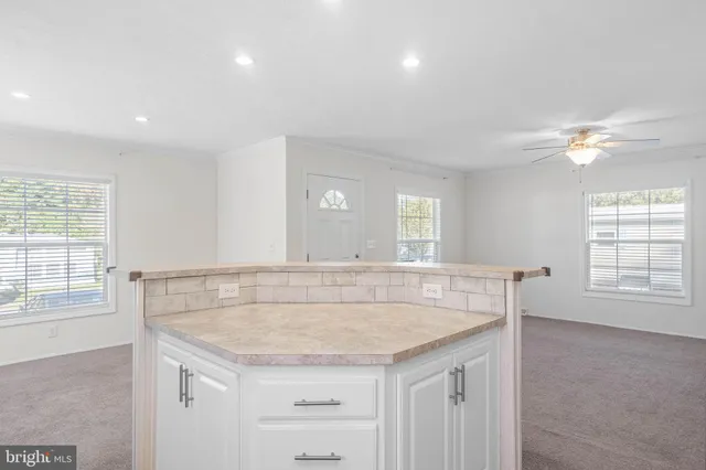 a view of kitchen with granite countertop cabinets and window