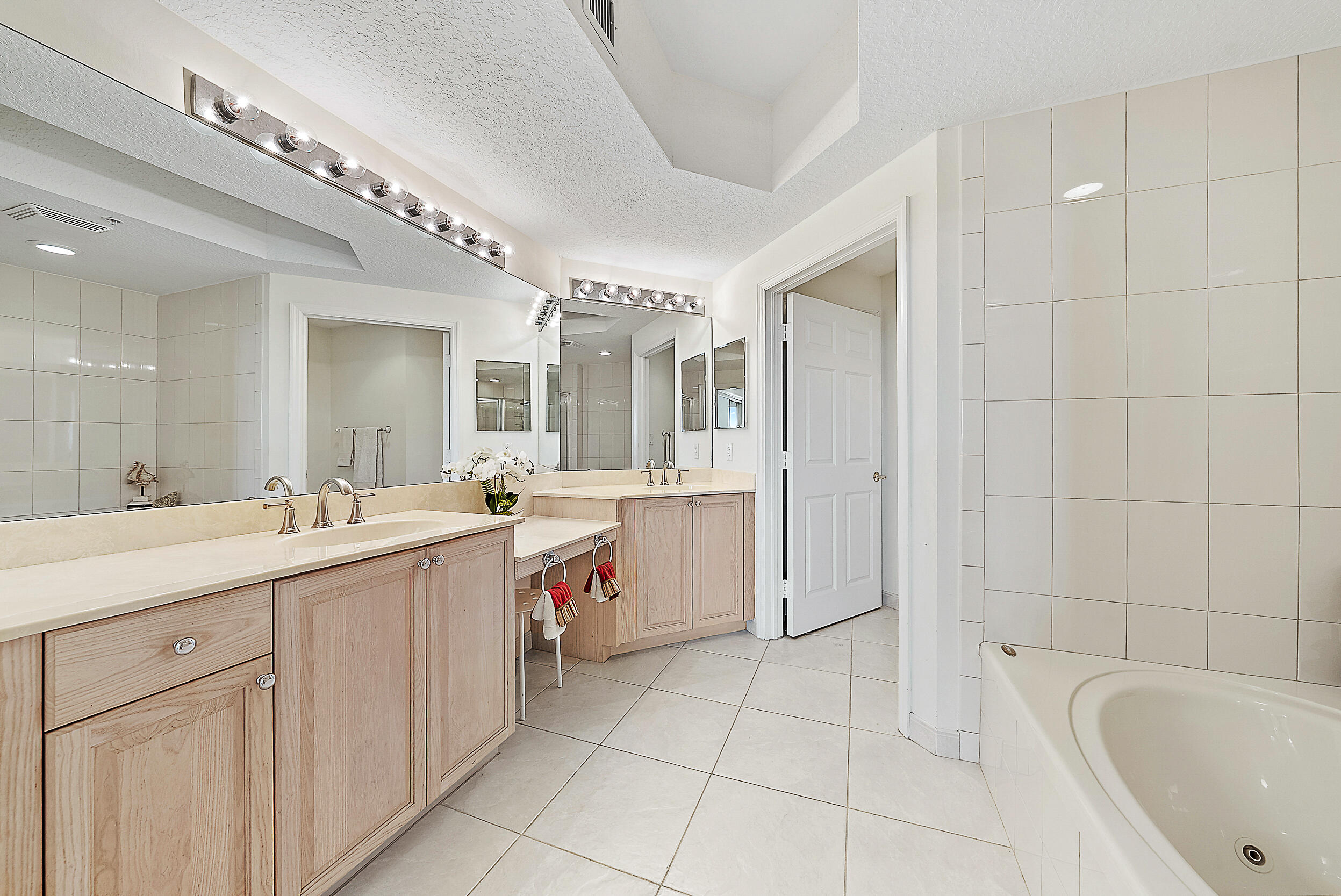 221 Ocean Grande Boulevard, Unit 407 Jupiter, FL 33477 - Photo 17 of 39 a spacious bathroom with a granite countertop sink mirror and bathtub