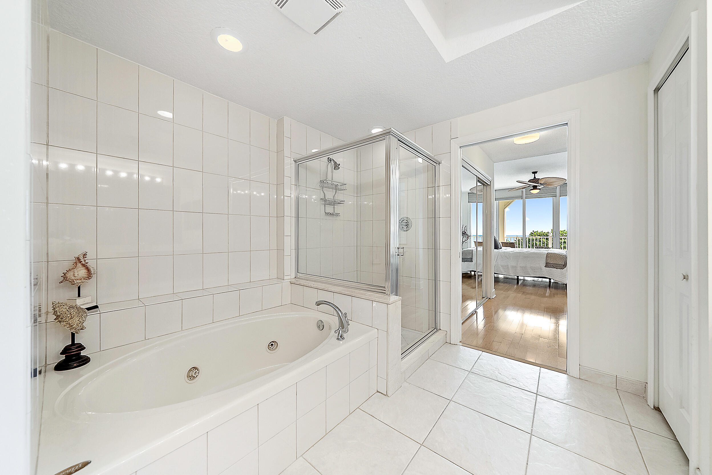 221 Ocean Grande Boulevard, Unit 407 Jupiter, FL 33477 - Photo 18 of 39 a bathroom with a bathtub and a shower