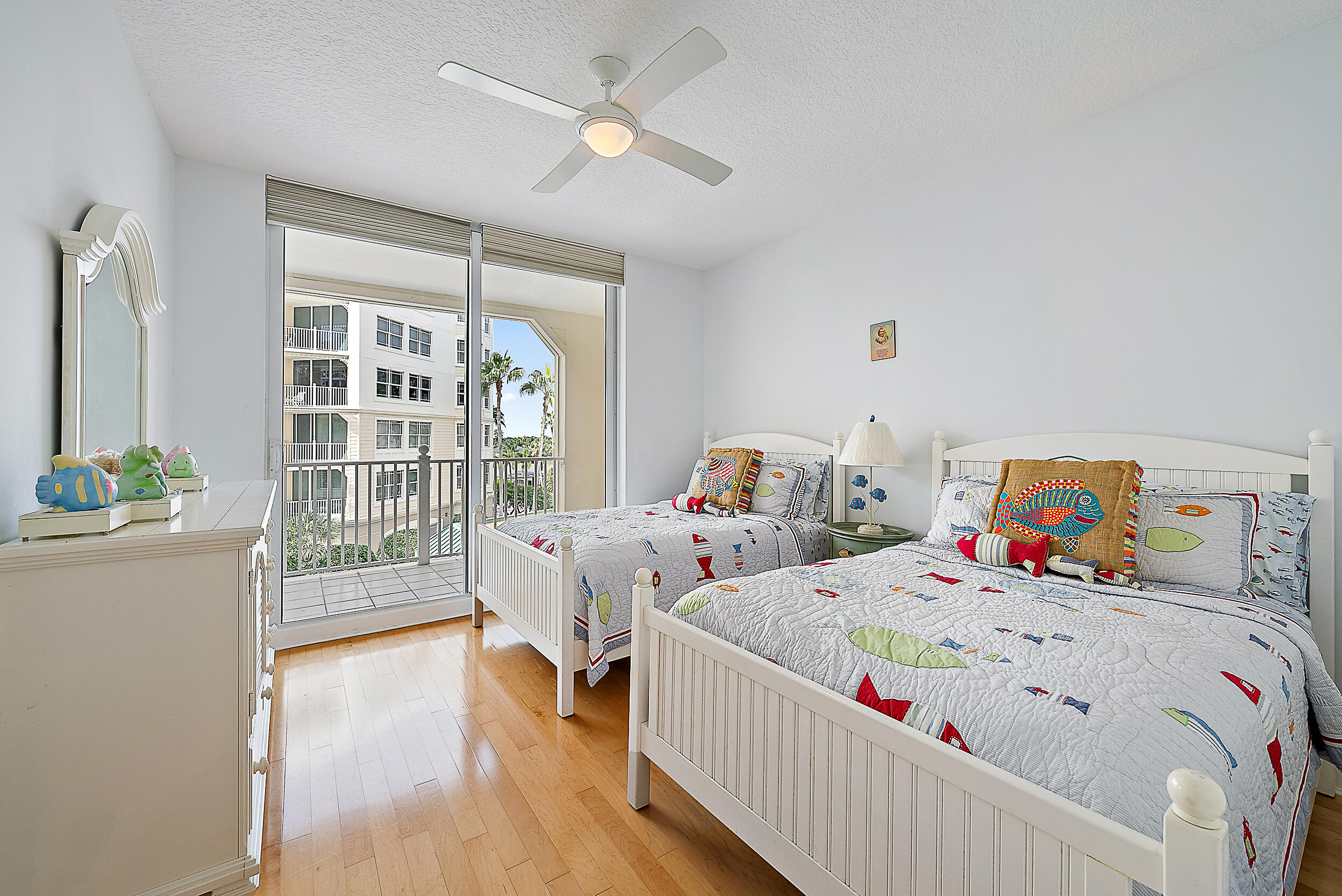 221 Ocean Grande Boulevard, Unit 407 Jupiter, FL 33477 - Photo 21 of 39 a bedroom with two beds and a wooden floor
