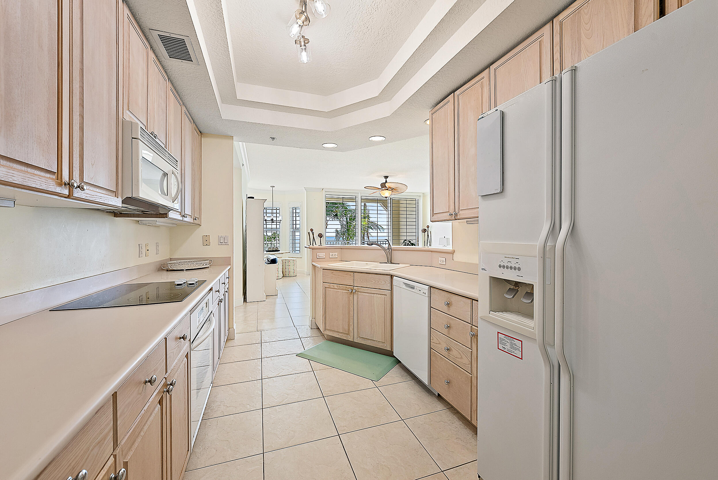 221 Ocean Grande Boulevard, Unit 407 Jupiter, FL 33477 - Photo 9 of 39 a kitchen with a sink cabinets and appliances