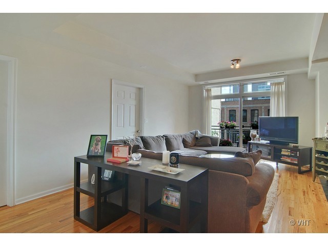 657 West Fulton Street, Unit 501 Chicago, IL 60661 - Photo 2 of 11 a living room with furniture a large window and wooden floor