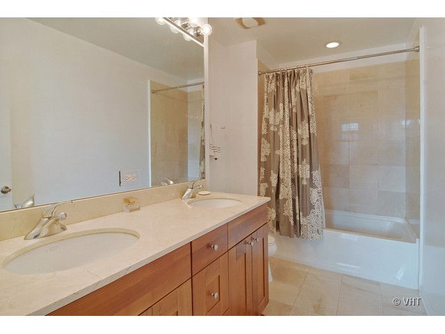 657 West Fulton Street, Unit 501 Chicago, IL 60661 - Photo 7 of 11 a bathroom with a sink a shower and a mirror