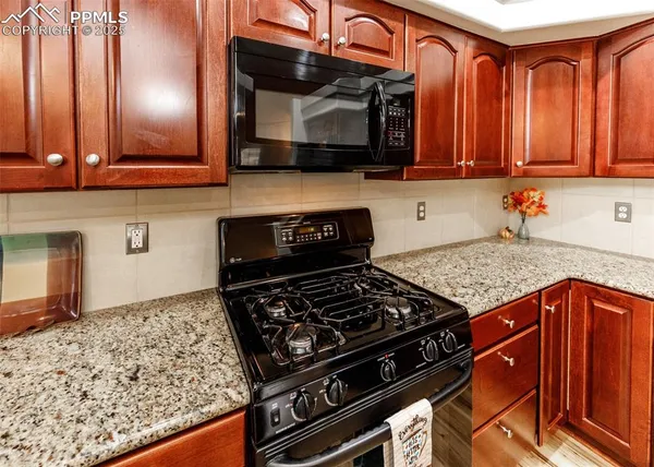 a kitchen with stainless steel appliances granite countertop a stove and a microwave