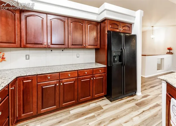 a kitchen with stainless steel appliances granite countertop a refrigerator and cabinets