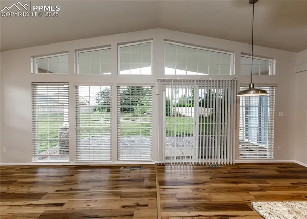 a view of a livingroom with wooden floor and a floor to ceiling window