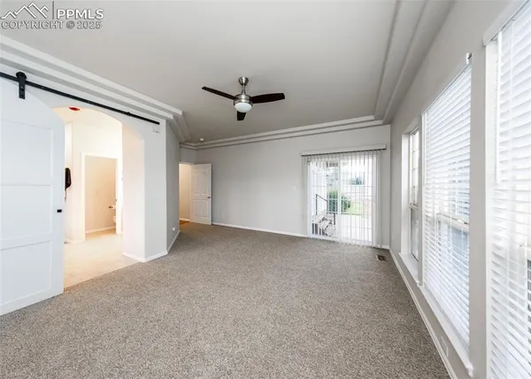 a view of a big room with wooden floor and windows