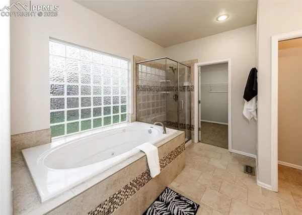a spacious bathroom with a tub sink and mirror