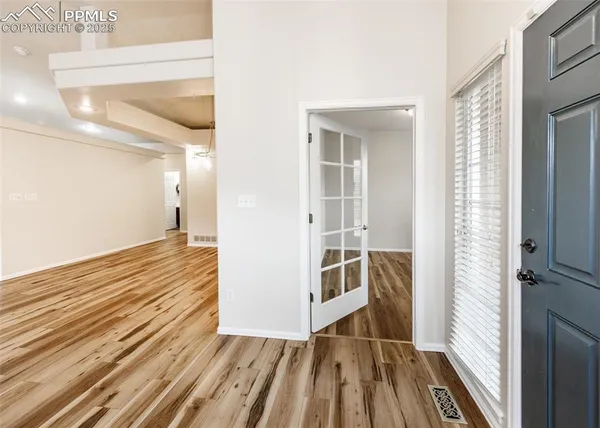 a view of a hallway with wooden floor and staircase