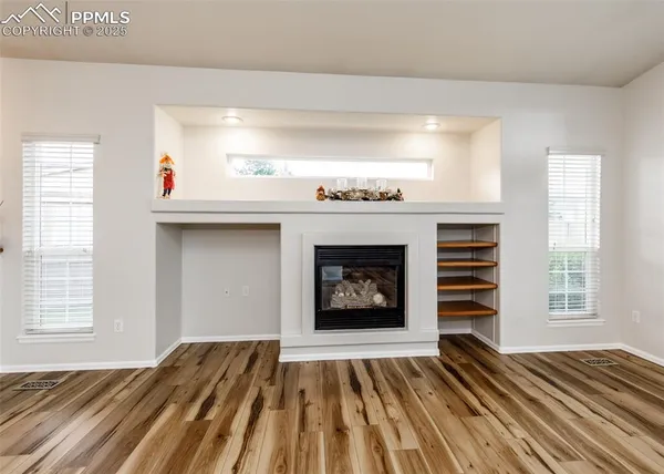 a view of an empty room with a fireplace and a window