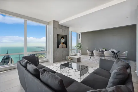 a living room with furniture and a floor to ceiling window