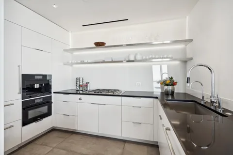 a kitchen with granite countertop white cabinets and stainless steel appliances