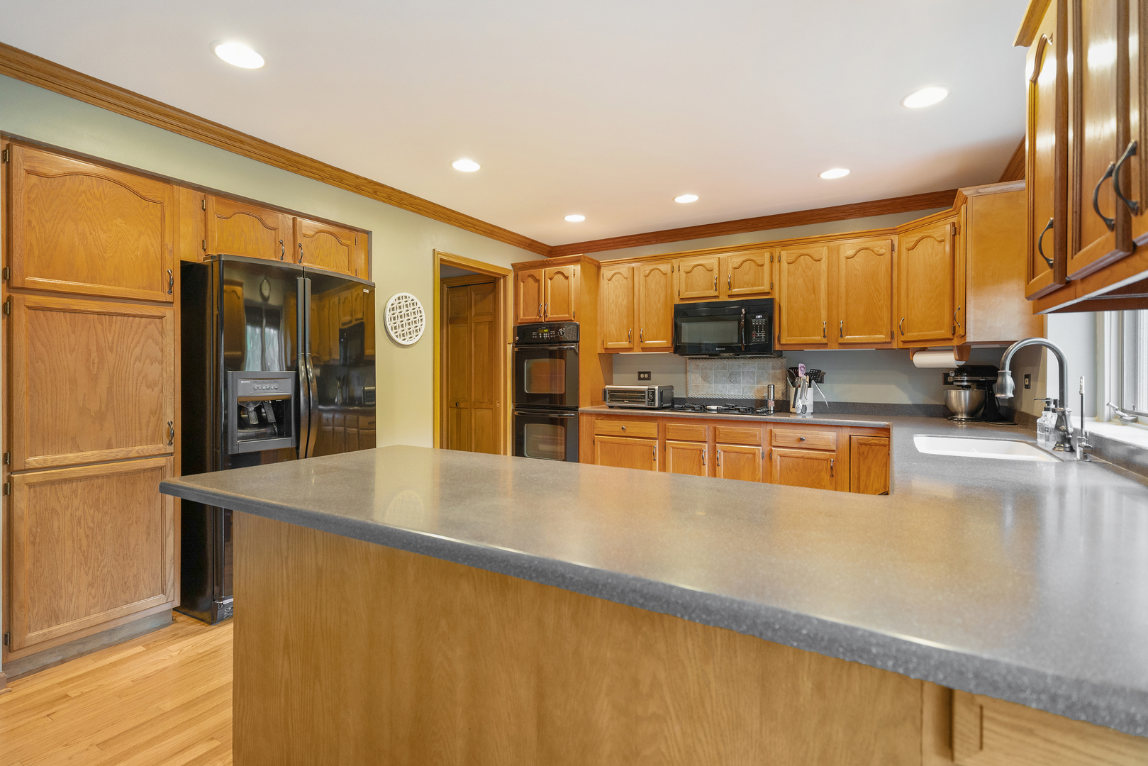 10317 Ridge Lane Huntley, IL 60142 - Photo 12 of 42 a large kitchen with stainless steel appliances a large counter top a stove and a refrigerator