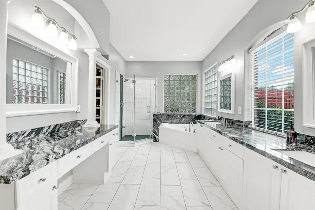 a large white kitchen with a large window and stainless steel appliances