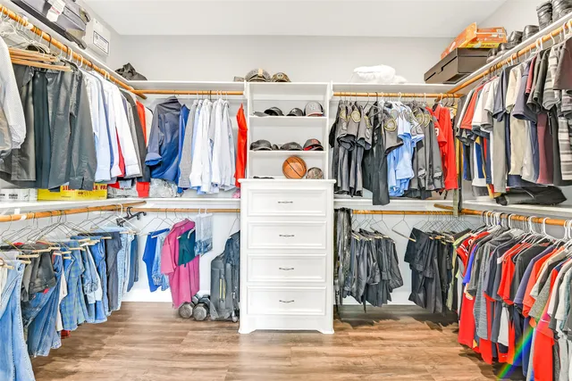 a view of walk in closet with clothes