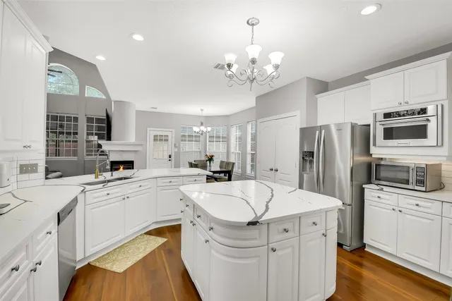 a kitchen with a sink stainless steel appliances and white cabinets